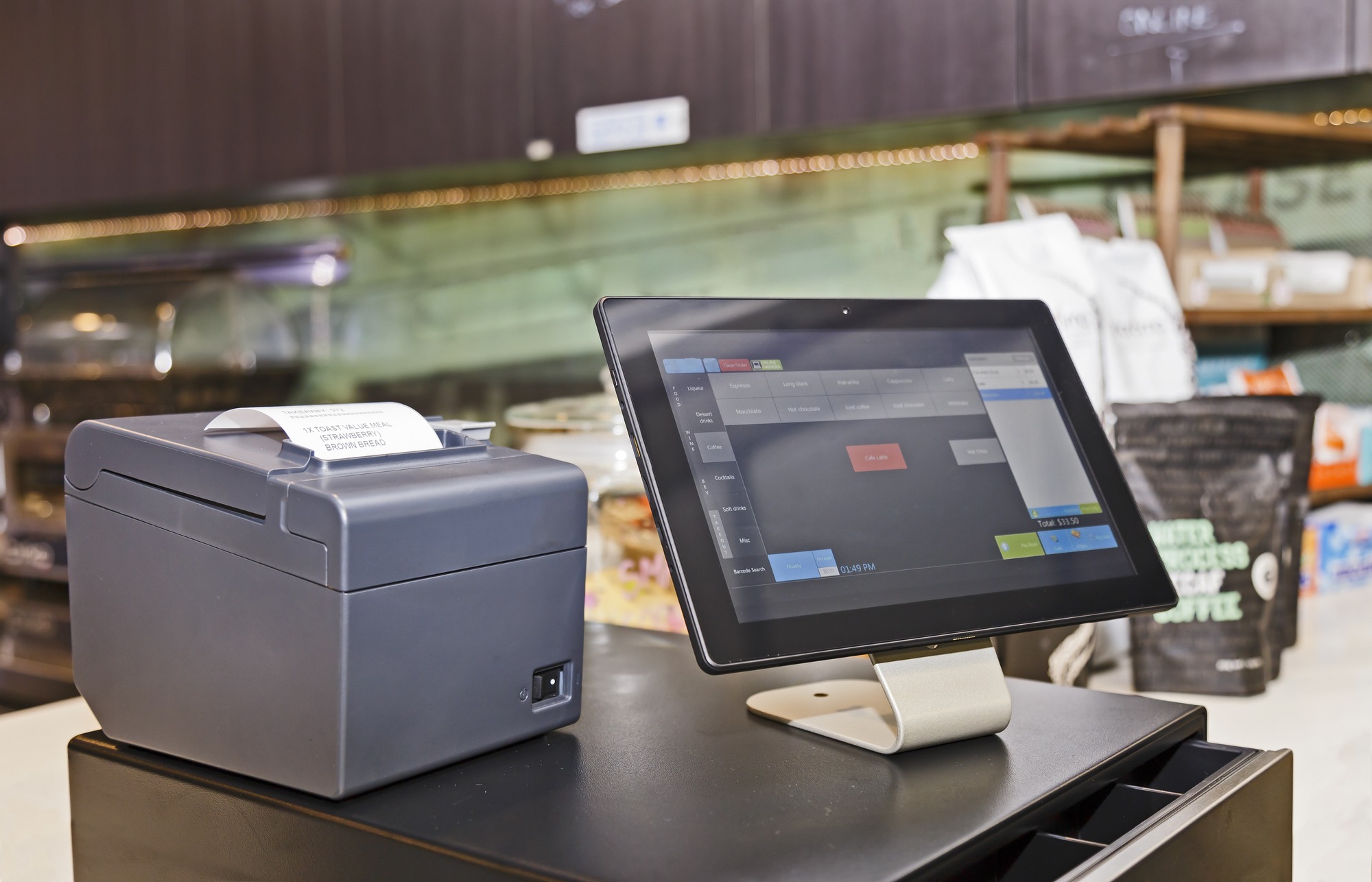 Point of Sale retail service computerised terminal in coffee shop. Touch screen tablet based with software interface for waiters with cash register and mobile print terminal.